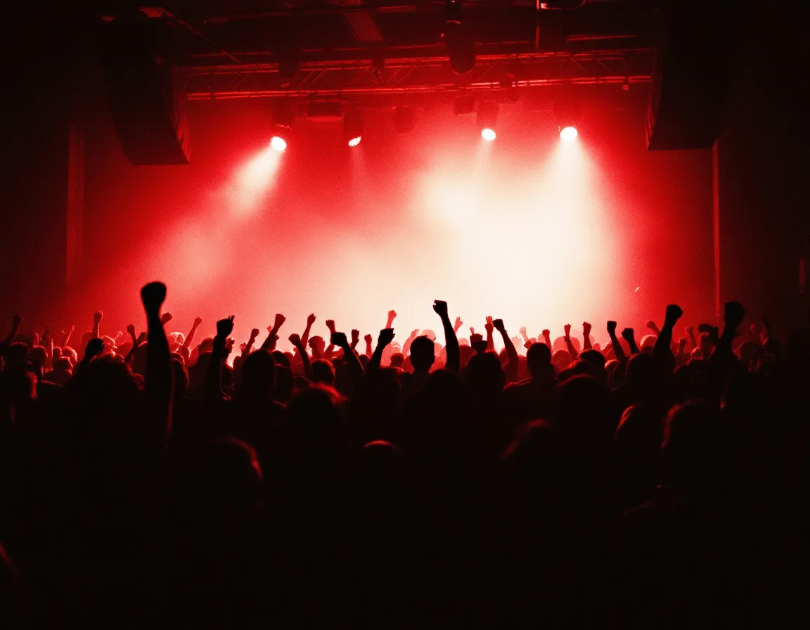 Static Mercy crowd from the pit under red stage lights